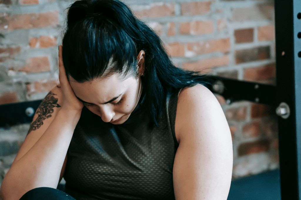 Woman frustrated in the gym holding her hand